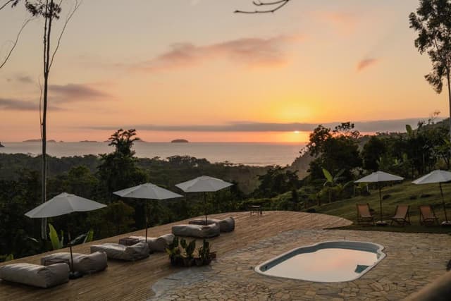 Pool and loungers facing the sea at sunset
